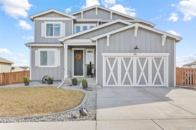 view of front of home with concrete driveway, board and batten siding, an attached garage, and fence