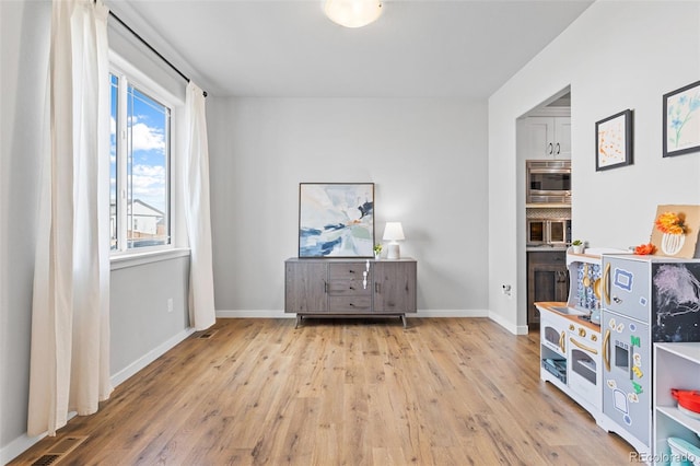 interior space featuring visible vents, baseboards, and wood finished floors