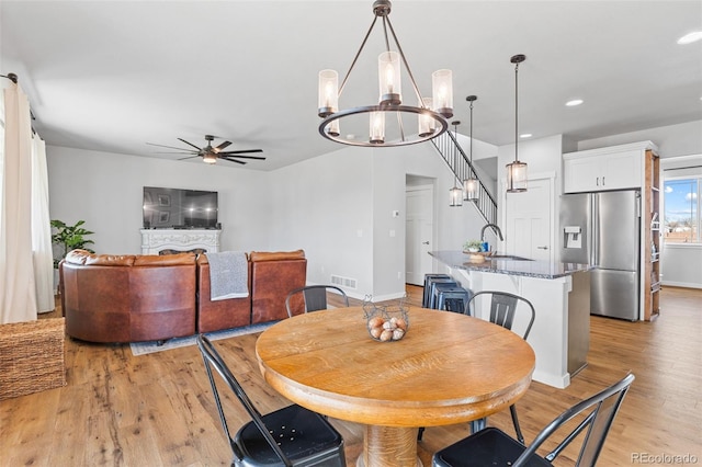 dining room with ceiling fan with notable chandelier, recessed lighting, visible vents, and light wood-style floors