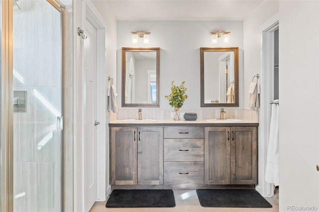 bathroom with double vanity, a sink, and a shower with door