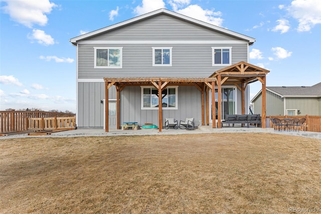 back of property featuring board and batten siding, a lawn, fence, a patio area, and a pergola