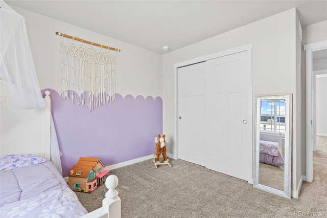 bedroom with carpet floors, baseboards, and a closet