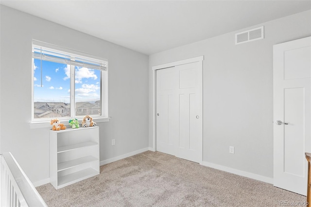 unfurnished bedroom featuring carpet, visible vents, and baseboards