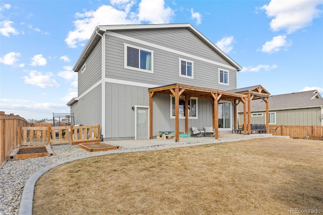 back of property with a yard, a patio area, a fenced backyard, and a vegetable garden