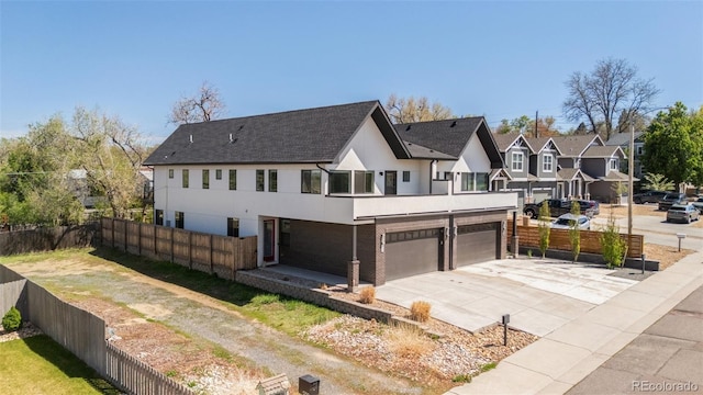 5240 N Raleigh St, Denver, CO 80212 - back of property featuring a garage, stucco siding, driveway, a residential view, and roof with shingles