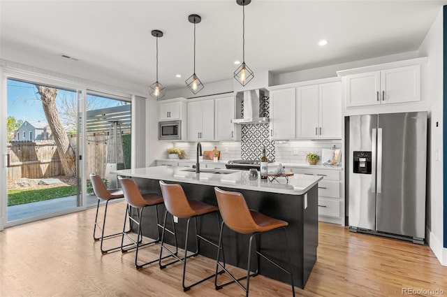5240 N Raleigh St, Denver, CO 80212 - kitchen featuring appliances with stainless steel finishes, wall chimney exhaust hood, a sink, a kitchen island with sink, and backsplash