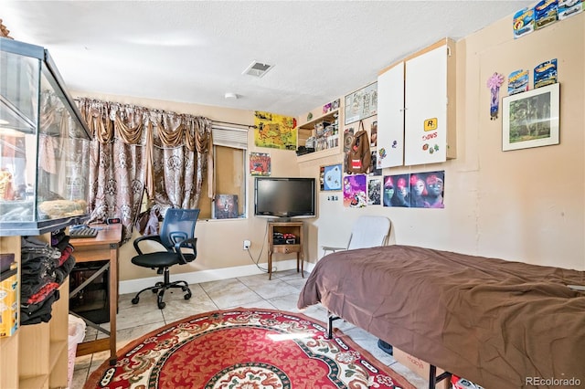 bedroom with a textured ceiling and light tile patterned floors