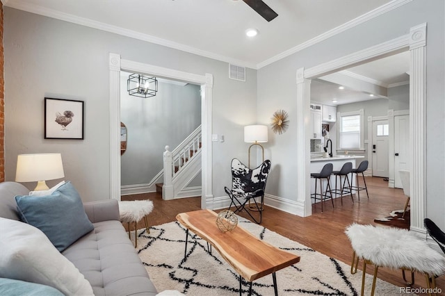 living room featuring dark wood finished floors, visible vents, stairway, ornamental molding, and baseboards