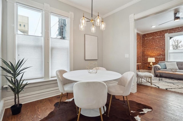 dining space with brick wall, ornamental molding, and dark wood-type flooring