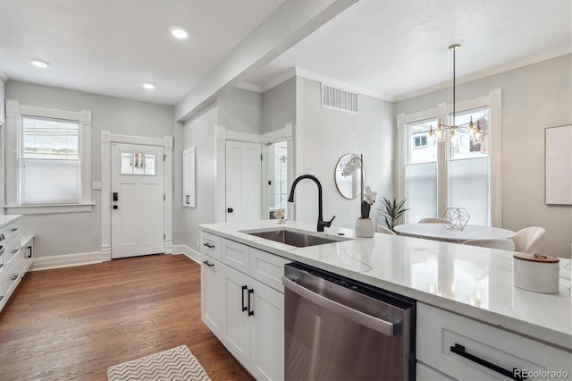 kitchen with visible vents, dishwasher, decorative light fixtures, white cabinetry, and a sink