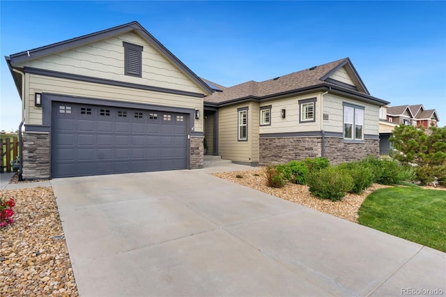 view of front facade with an attached garage, stone siding, and concrete driveway