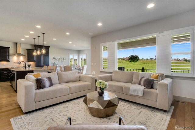 17637 W 87th Ave, Arvada, CO 80007 - living room featuring recessed lighting, light wood-style floors, a chandelier, and baseboards