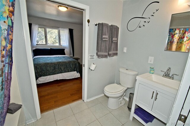246 Baca Grant Way, Crestone, CO 81131 - ensuite bathroom featuring toilet, vanity, ensuite bath, tile patterned flooring, and baseboards