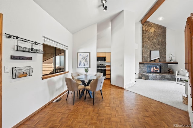 501 Manhattan Dr Unit 202, Boulder, CO 80303 - dining space with baseboards, high vaulted ceiling, and a stone fireplace