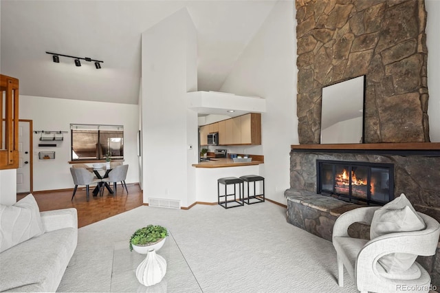501 Manhattan Dr Unit 202, Boulder, CO 80303 - carpeted living area with rail lighting, baseboards, a fireplace, and high vaulted ceiling