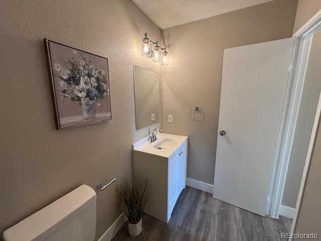 bathroom featuring vanity, toilet, and hardwood / wood-style floors