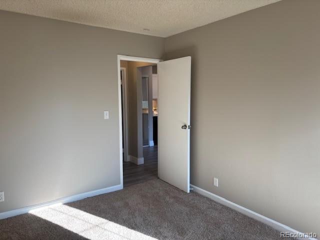 carpeted spare room featuring a textured ceiling