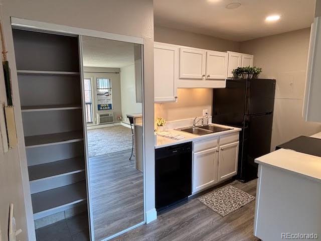 kitchen featuring sink, white cabinetry, black appliances, and dark hardwood / wood-style flooring