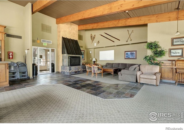 living room featuring wooden ceiling, beam ceiling, a towering ceiling, and a fireplace