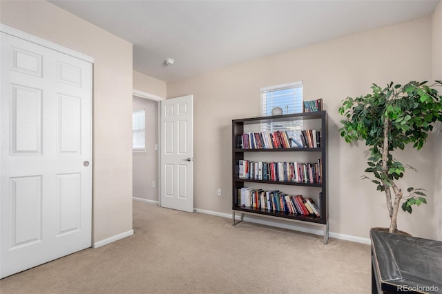 living area with a healthy amount of sunlight and light carpet