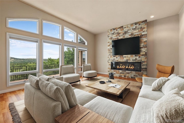 living room with a wealth of natural light, light hardwood / wood-style flooring, and lofted ceiling