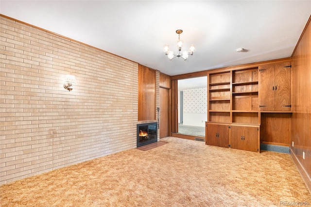 6019 Taft Ct, Arvada, CO 80004 - unfurnished living room with brick wall, a chandelier, a lit fireplace, carpet, and wood walls