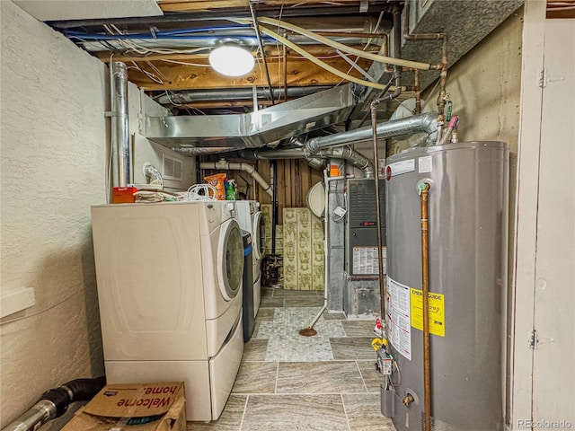 unfinished below grade area featuring washer and clothes dryer, heating unit, gas water heater, and stone finish floor