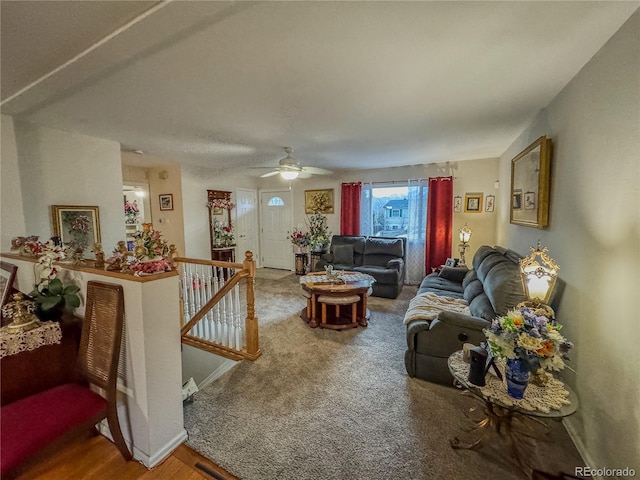 carpeted living room featuring baseboards and a ceiling fan