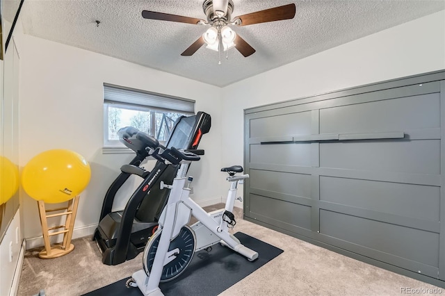 workout room with ceiling fan, light carpet, and a textured ceiling