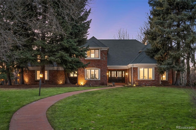 view of front facade with a front lawn and brick siding