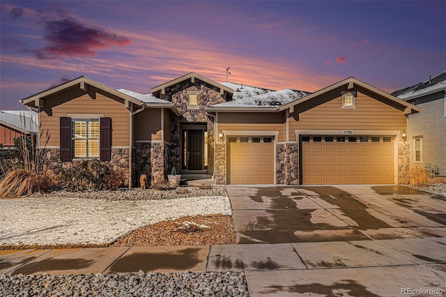 view of front of house with stone siding, an attached garage, and concrete driveway