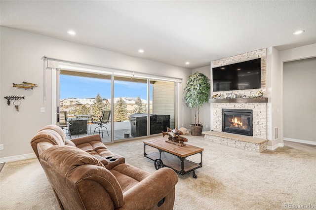 carpeted living room with recessed lighting, a large fireplace, and baseboards