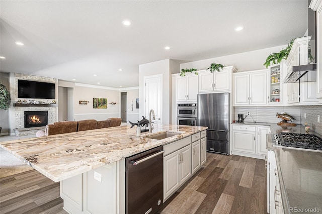 kitchen featuring a center island with sink, white cabinetry, stainless steel appliances, and a sink