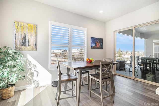 dining space with recessed lighting, wood finished floors, baseboards, and a wealth of natural light