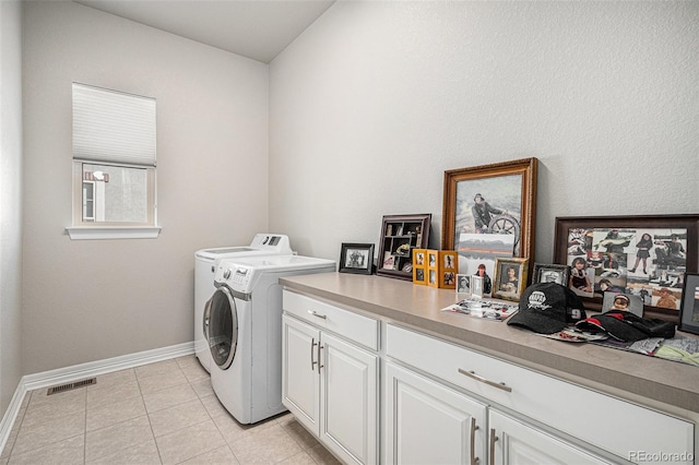 laundry room with visible vents, baseboards, cabinet space, light tile patterned flooring, and washer and dryer