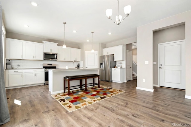 4209 Fox Grove Dr, Fort Collins, CO 80524 - kitchen featuring appliances with stainless steel finishes, wood finished floors, white cabinetry, backsplash, and recessed lighting