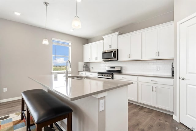 4209 Fox Grove Dr, Fort Collins, CO 80524 - kitchen featuring appliances with stainless steel finishes, a sink, dark wood-type flooring, backsplash, and a center island with sink