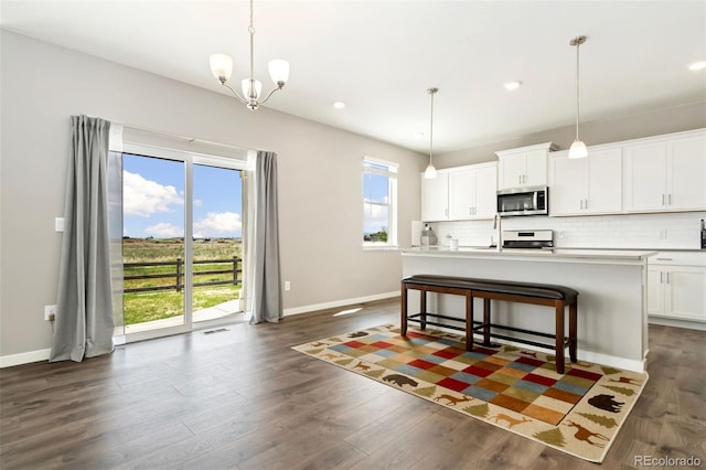 4209 Fox Grove Dr, Fort Collins, CO 80524 - kitchen featuring stainless steel microwave, stove, baseboards, tasteful backsplash, and dark wood-style flooring