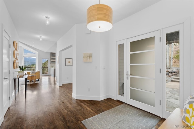 interior space featuring baseboards, vaulted ceiling, and wood finished floors