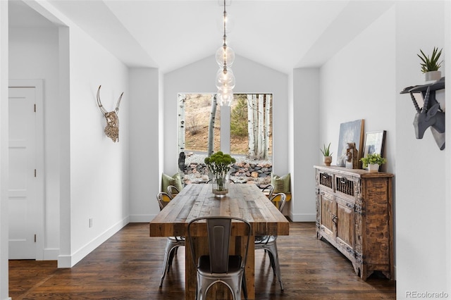 dining area featuring dark wood-type flooring, lofted ceiling, and baseboards