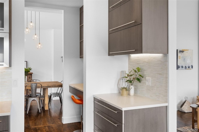 kitchen featuring light countertops, backsplash, modern cabinets, dark wood-type flooring, and dark brown cabinets