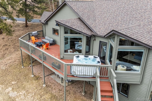 rear view of property with stairs, a hot tub, roof with shingles, and a wooden deck