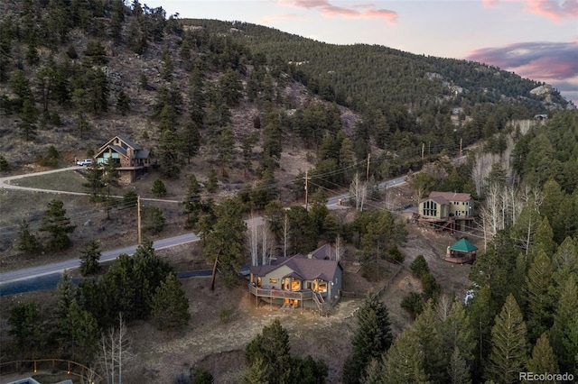 aerial view at dusk with a mountain view and a view of trees
