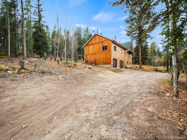 view of side of home featuring a garage and an outbuilding