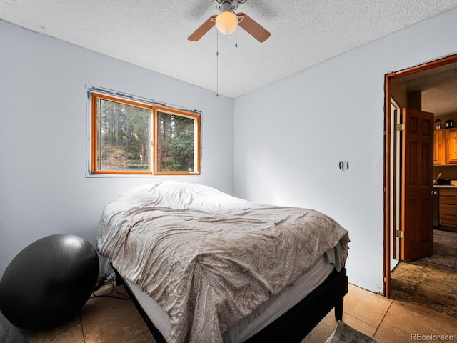 tiled bedroom with a textured ceiling and ceiling fan