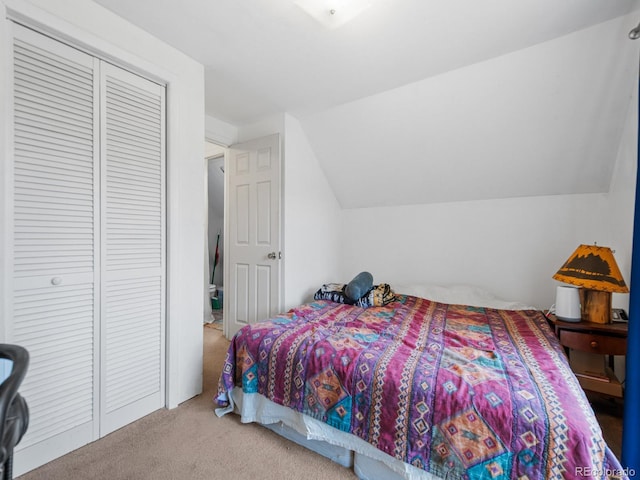 bedroom featuring lofted ceiling, light colored carpet, and a closet