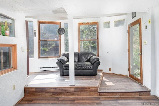 interior space featuring a baseboard heating unit, wood finished floors, and a textured wall