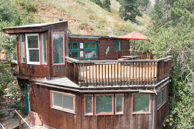 rear view of house featuring a wooden deck