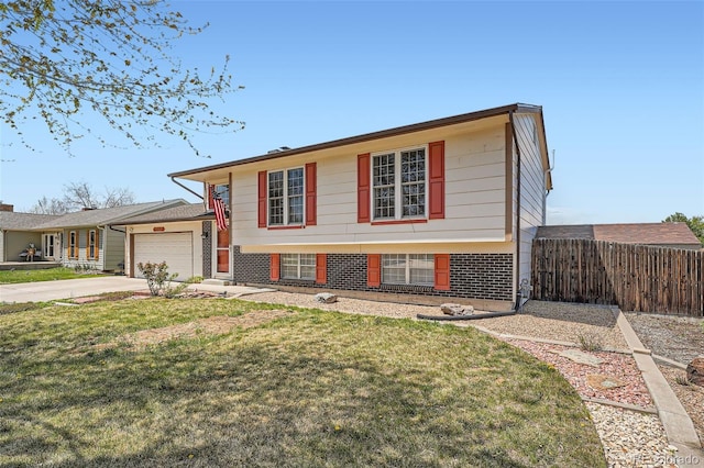 tri-level home featuring a garage, a front lawn, fence, brick siding, and concrete driveway