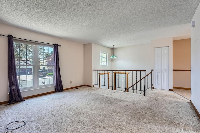 unfurnished room featuring baseboards, carpet flooring, and a textured ceiling